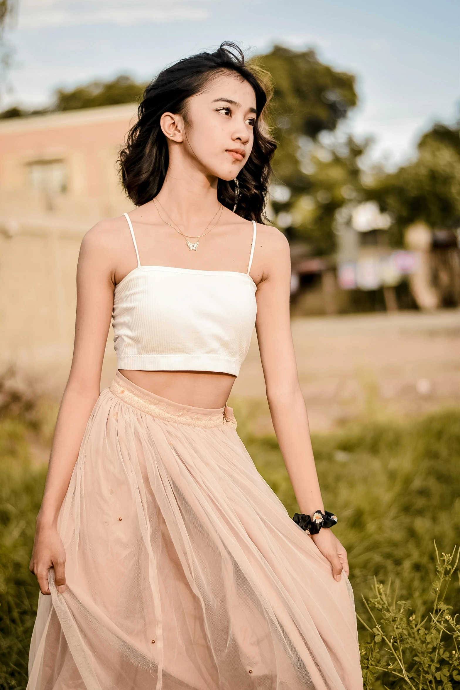 young woman posing in front of grassy field