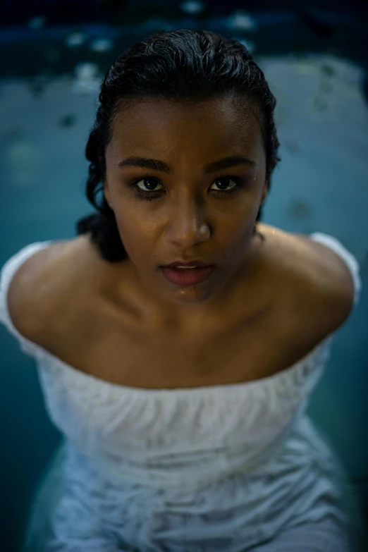 a woman wearing a white shirt in a pool looking straight ahead