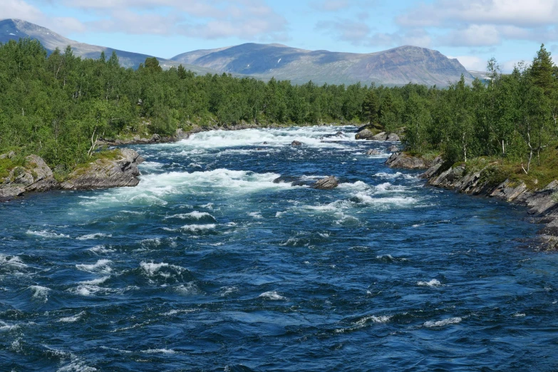 a beautiful scene of water with mountains in the background