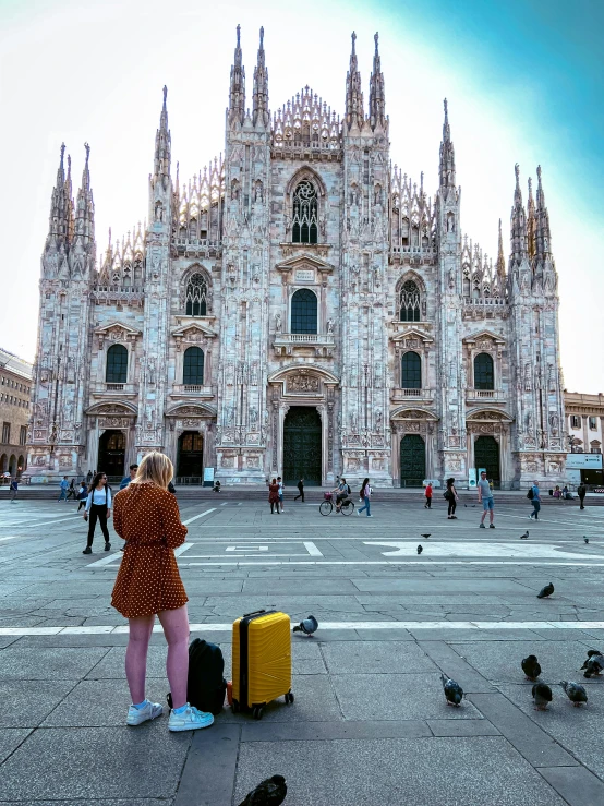 a person with a suitcase is outside a large building