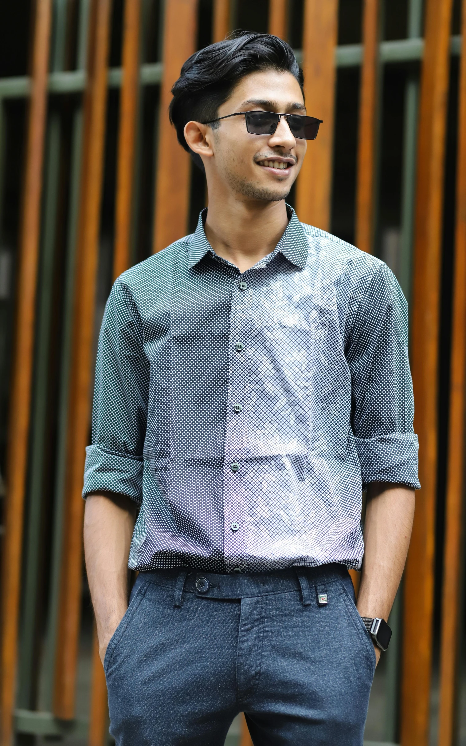 a man standing in front of a wooden fence