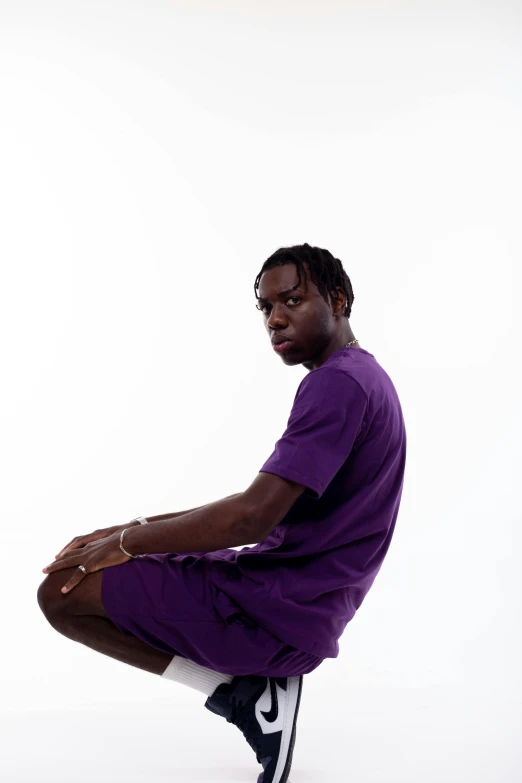 a young man sitting on the floor with his leg up