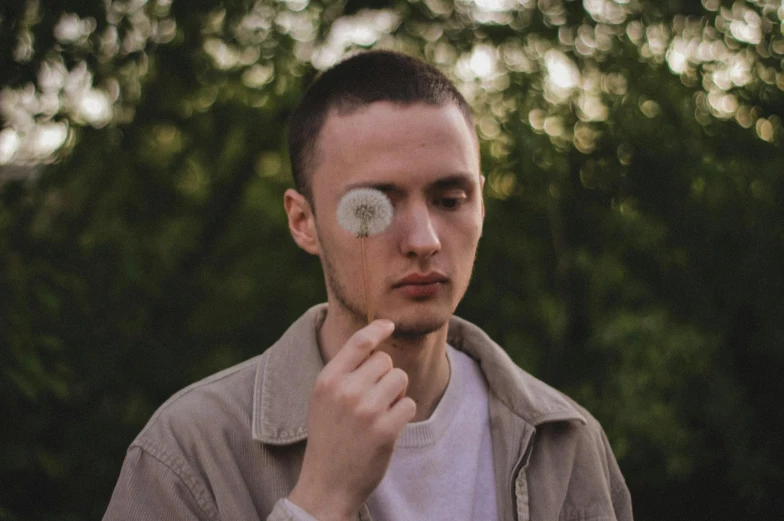 a man with some dandelions on his face looking to the left