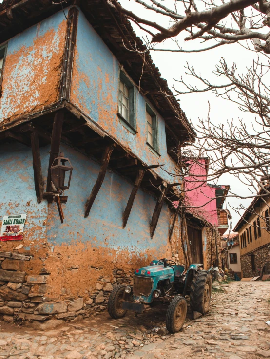 an old blue house with an antique tractor