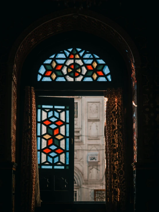 a glass door leading to an arch with a large stained glass window