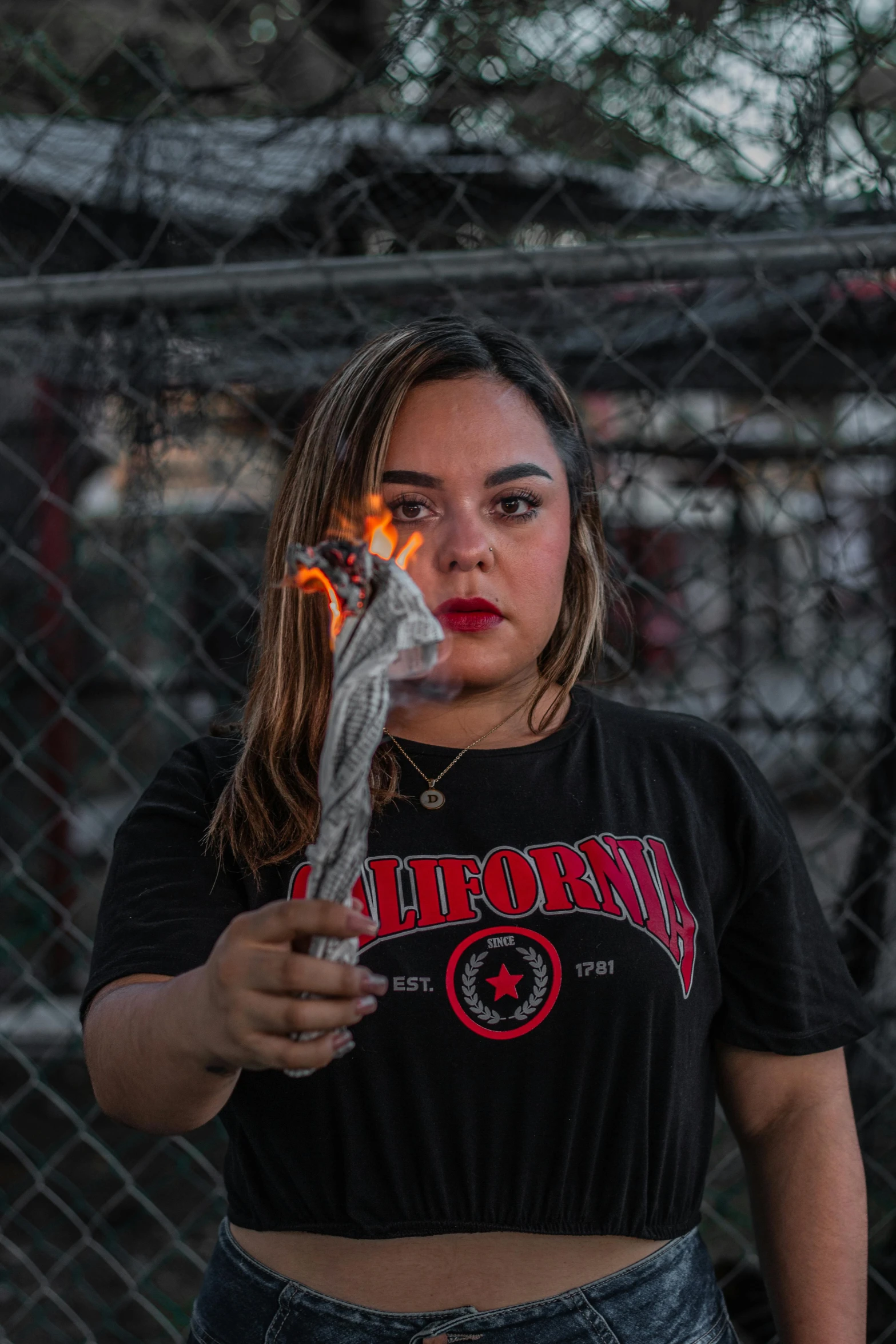 a woman in black shirt holding a cigarette lighter