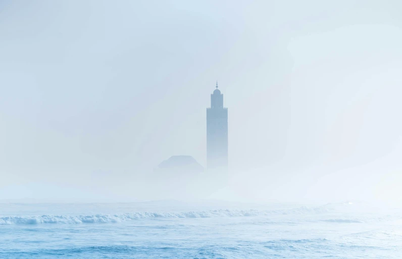 an ocean scene with a lighthouse in the distance