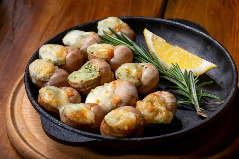 a plate of scallops topped with a green sprig