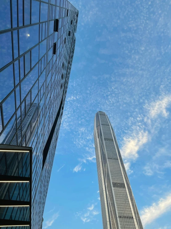 two tall skyscrs rise into the blue sky