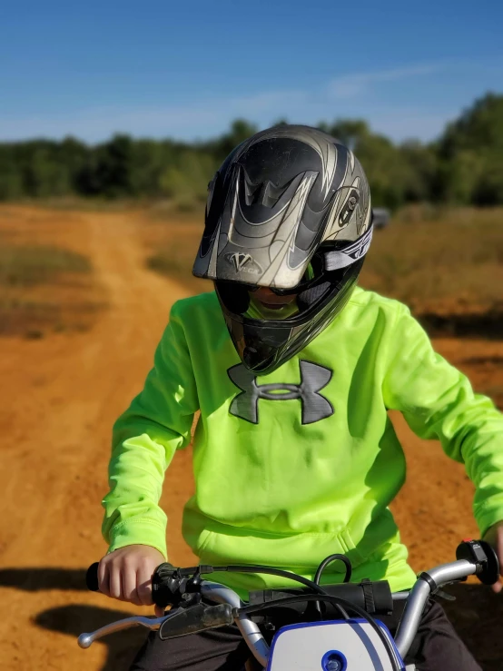 a child in yellow shirt riding a motorcycle