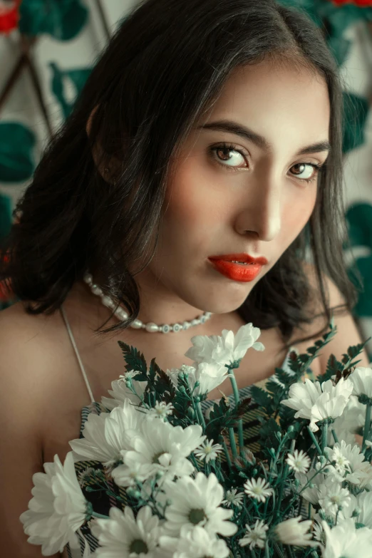 a beautiful young woman holding white flowers near her face