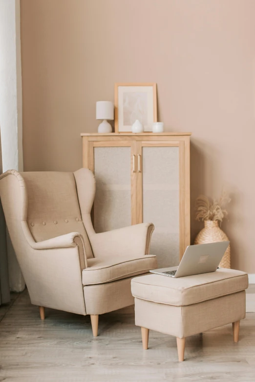 a chair and ottoman in a room with a beige wall