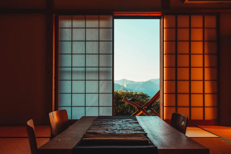 the view of mountains out an open window from inside a house