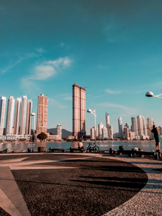 a group of people standing next to water and buildings