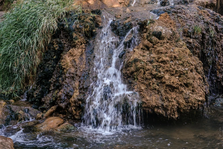 a small waterfall next to some large rocks