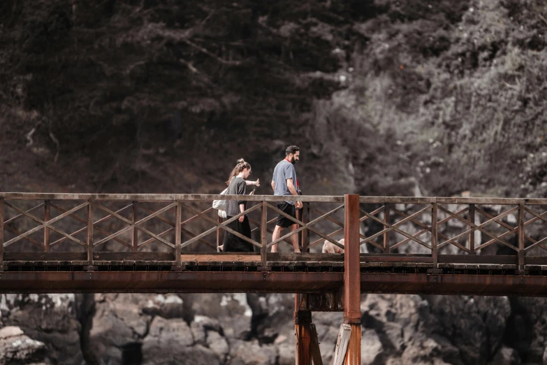 a couple running on a bridge over a body of water