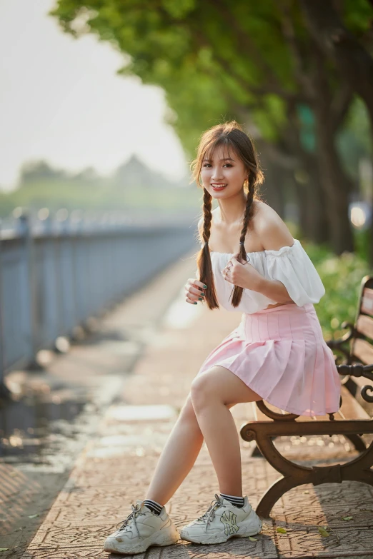 the woman is sitting on the bench near the water