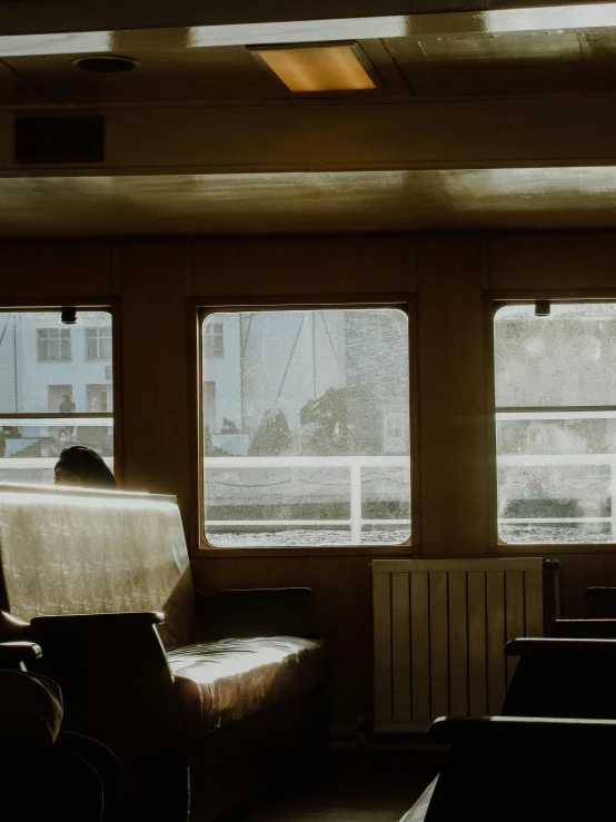 an empty living room with large windows and an armless chair