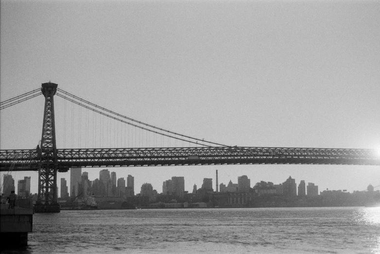 a large bridge with a long line of skyscrs in the distance