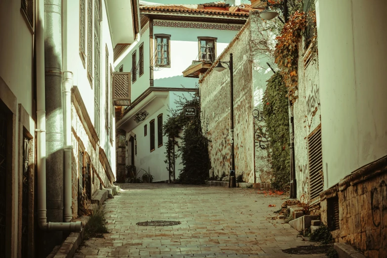 a brick paved street with tall, white buildings on both sides