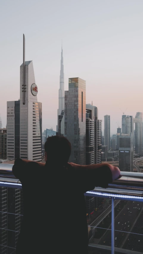 a person looks out over a cityscape at the horizon