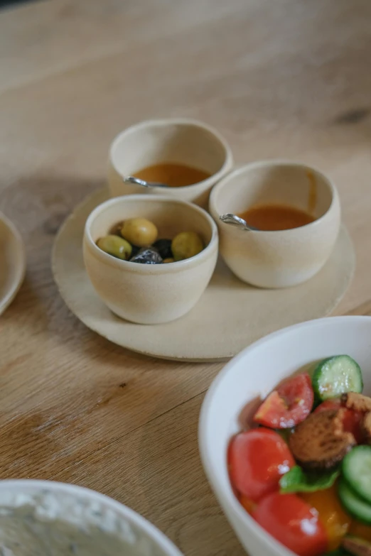 a table with three bowls of different foods