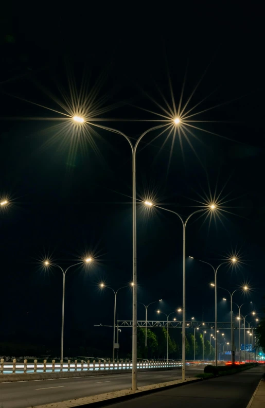 an empty street with many streetlights in the dark