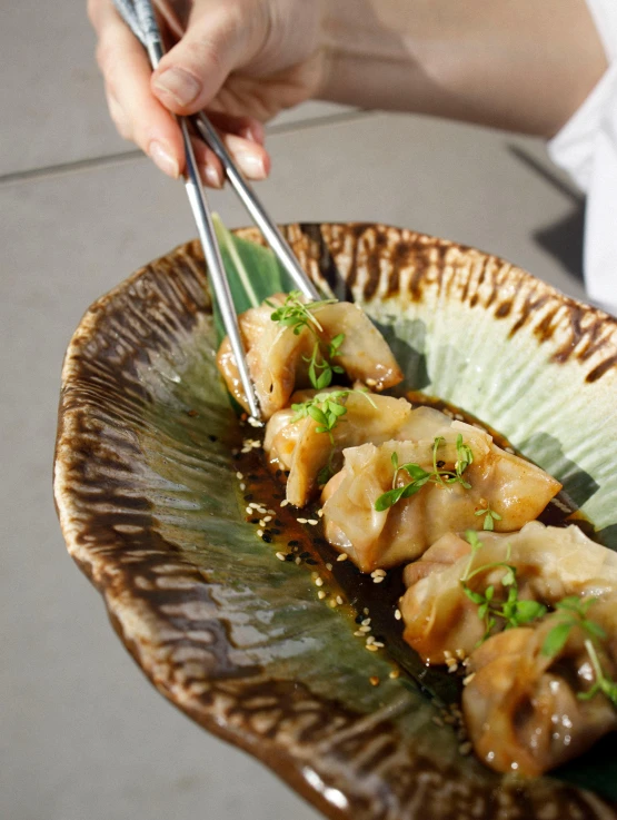 a close up of a plate of food with chopsticks