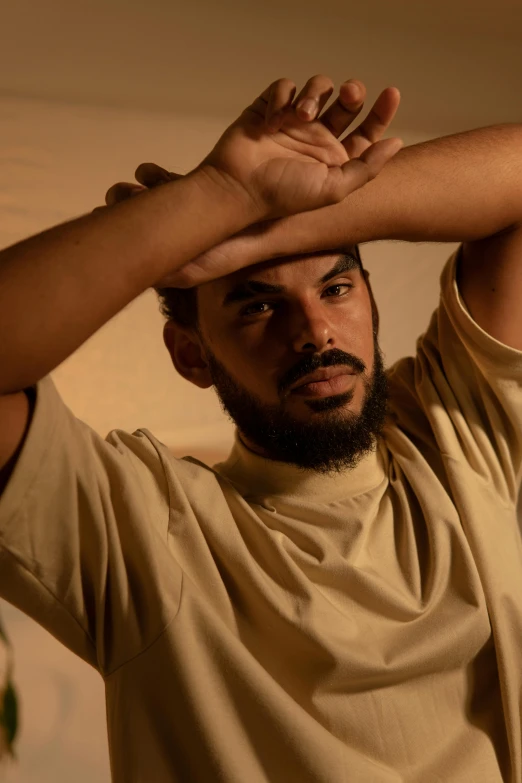 a man with a beard holds his hands up