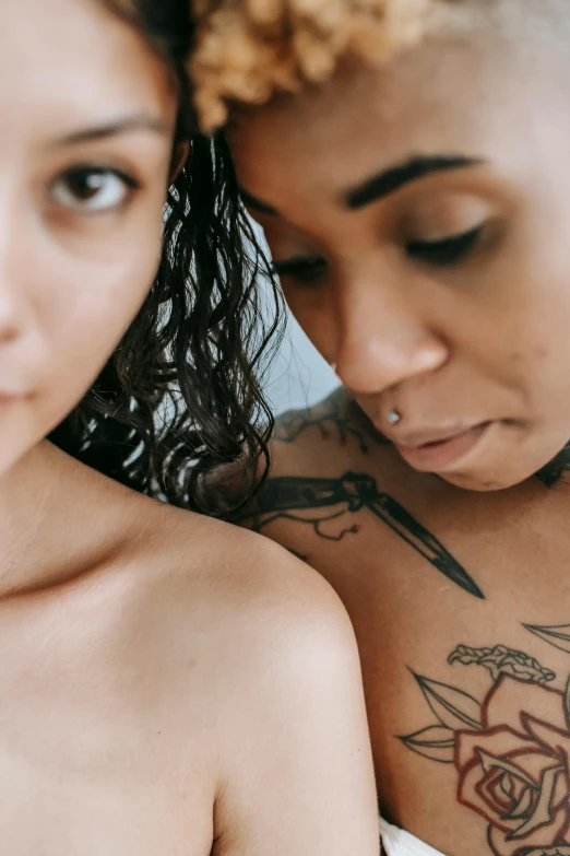 two women with tattoos on their stomachs next to each other