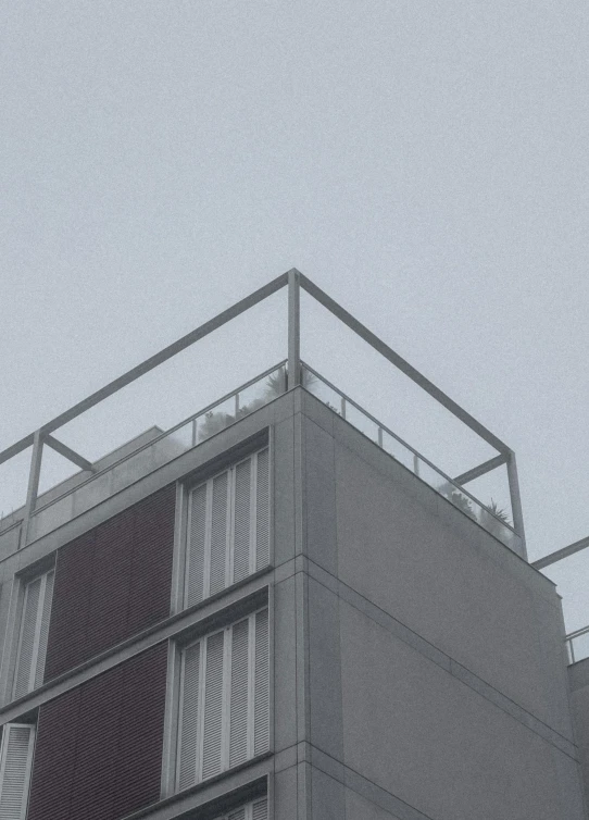 an air plane flies above a gray building