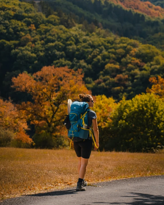 a young man riding on a skateboard down a dirt road