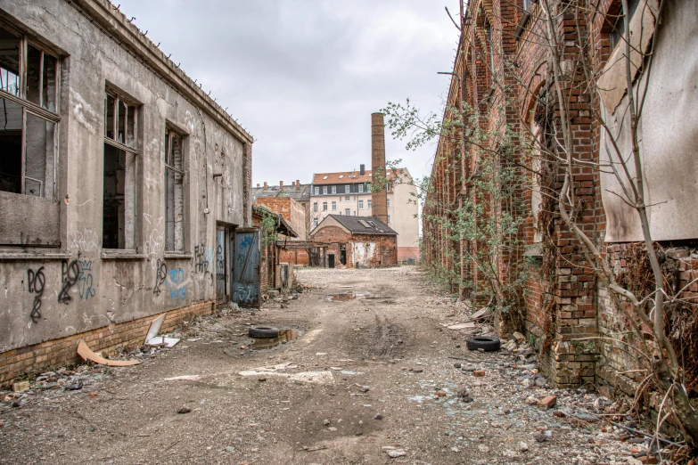 a dirt road going through an alley between two brick buildings