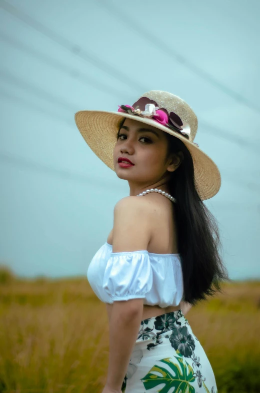 a woman in a white dress and straw hat