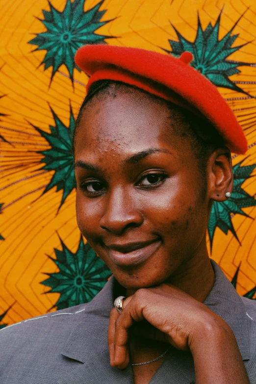 a woman is wearing a red hat in front of an orange and green background