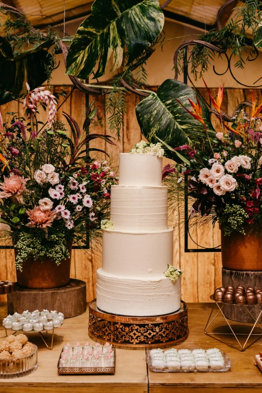 a white wedding cake on top of a wooden table