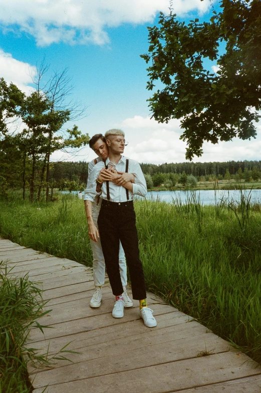 an old couple hugging on a path near water