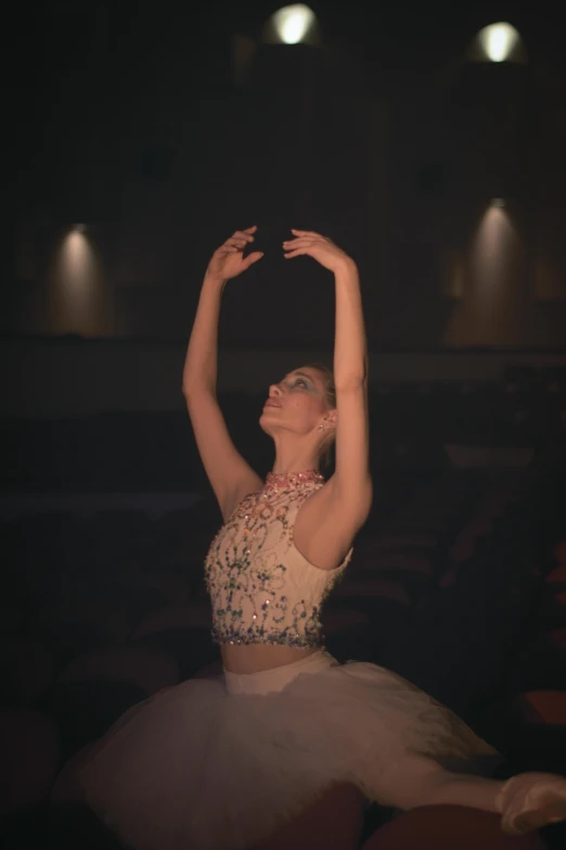 a dancer in a white dress standing in the middle of a dance pose