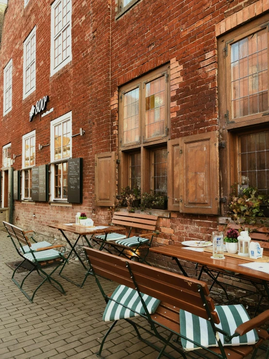 a brick building has green and white chairs