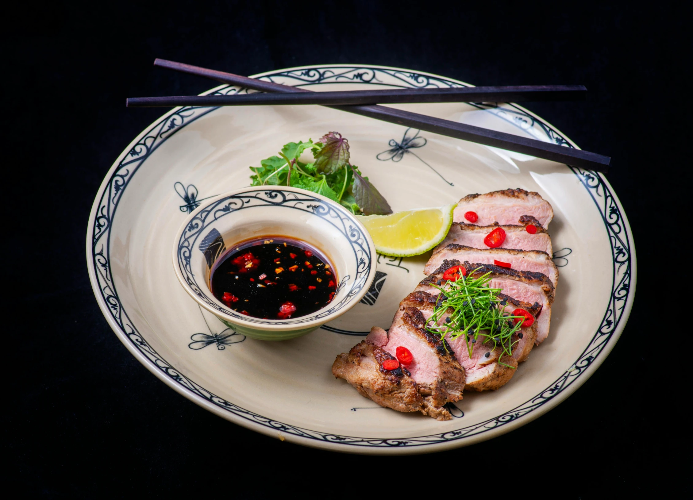 a plate of food with chop sticks and sauce