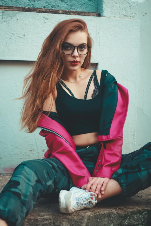 a woman in black shirt and red jacket sitting on cement