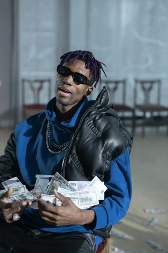 a man with purple hair and sunglasses is holding stacks of money
