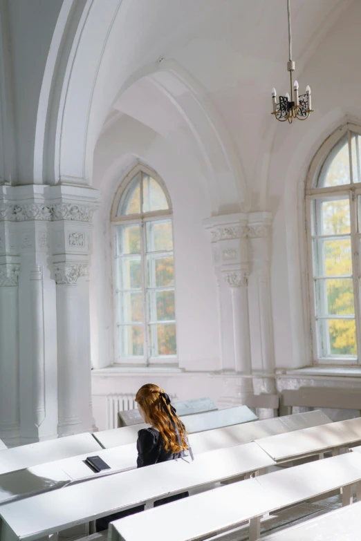 a room with two big windows and white benches