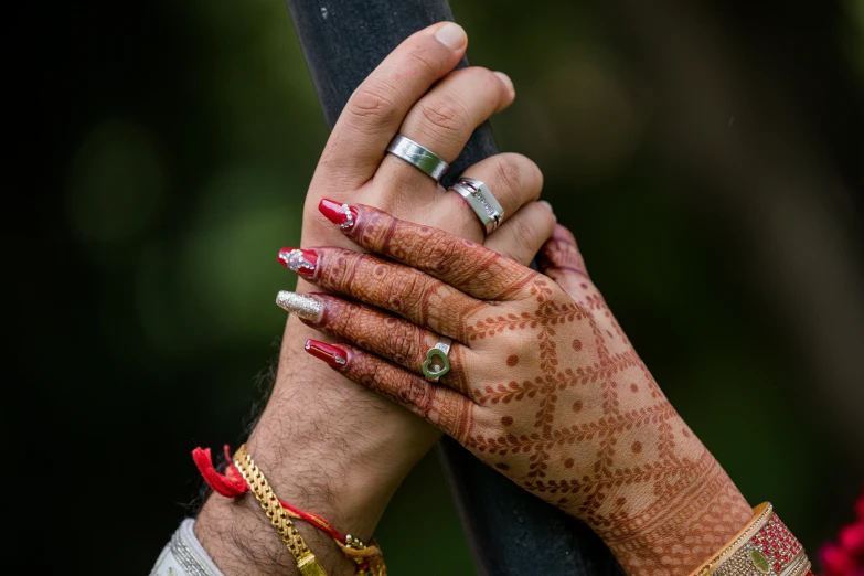 two hands with wedding bands holding each other