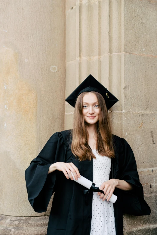 a woman is posing in her graduation cap and gown