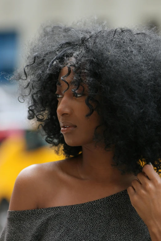 an african woman with black hair standing on the street