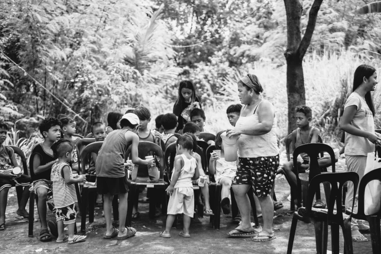 children are lined up in front of a man