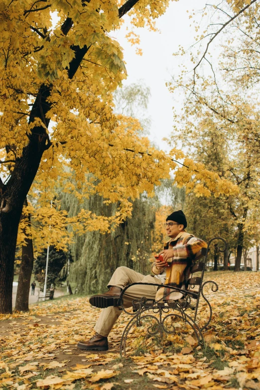 a man sitting on a bench while playing the violin