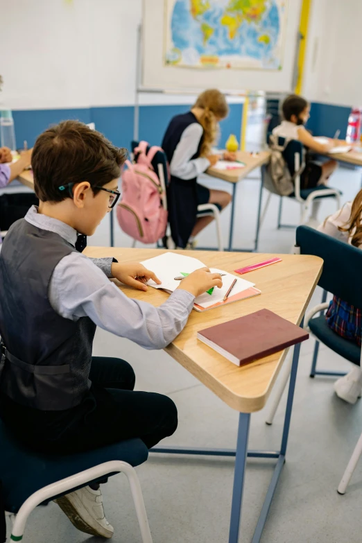 a  is doing homework in a classroom