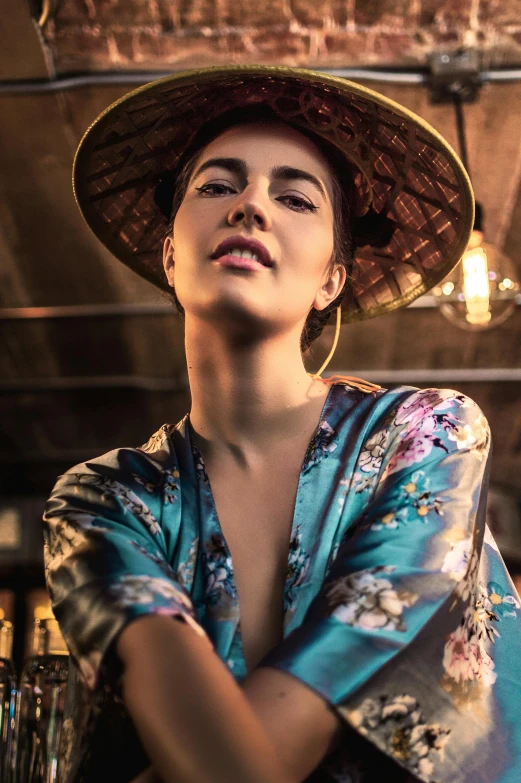 a beautiful young lady wearing a hat while sitting down